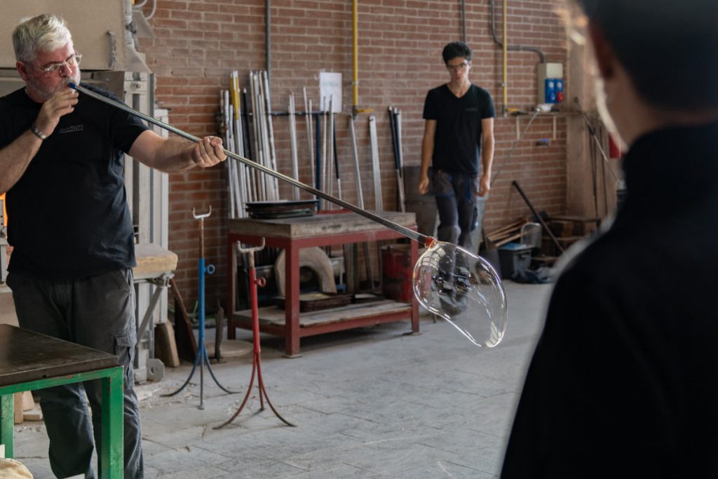 uomo che soffia il vetro