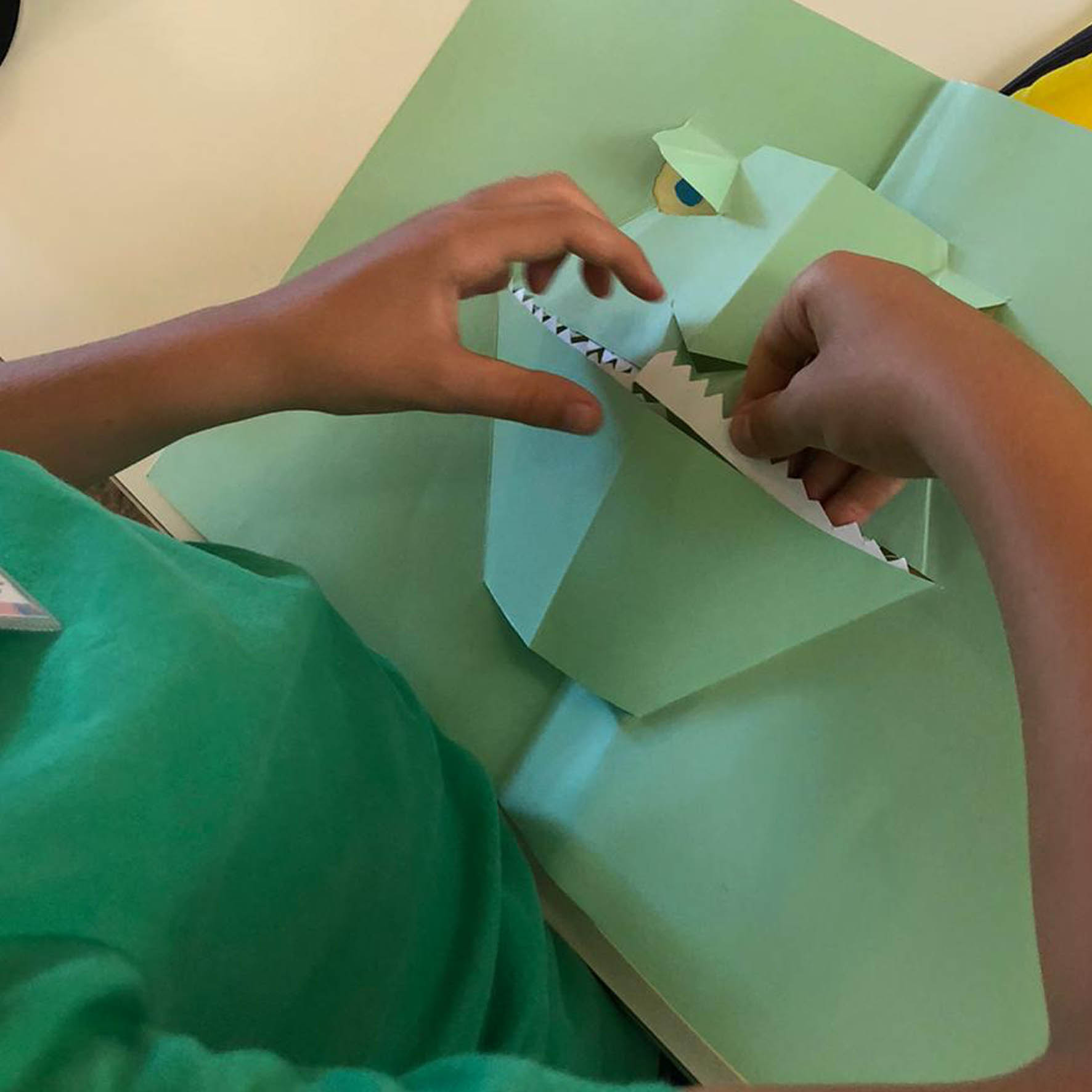 Mani di bambino che piega la carta per creare una scultura pop up